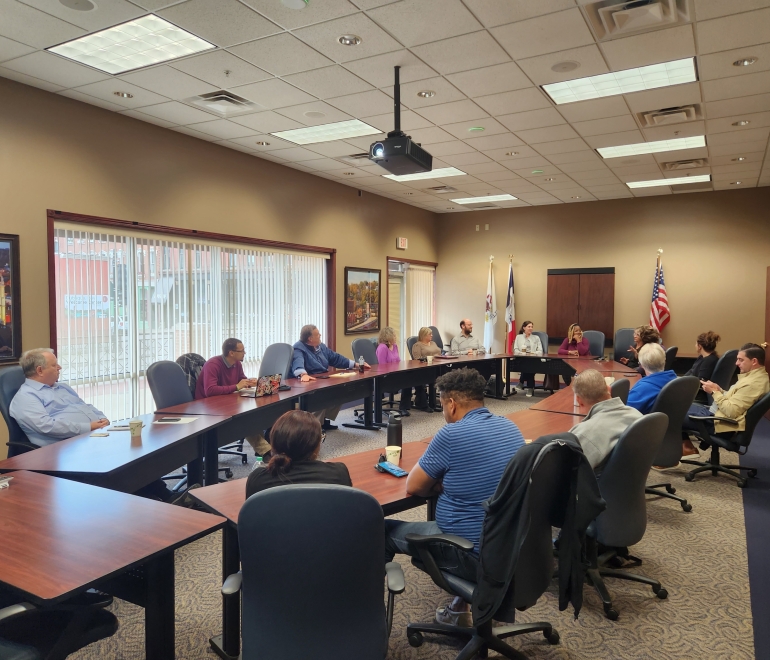 Group of people around wooden tables in a meeting room