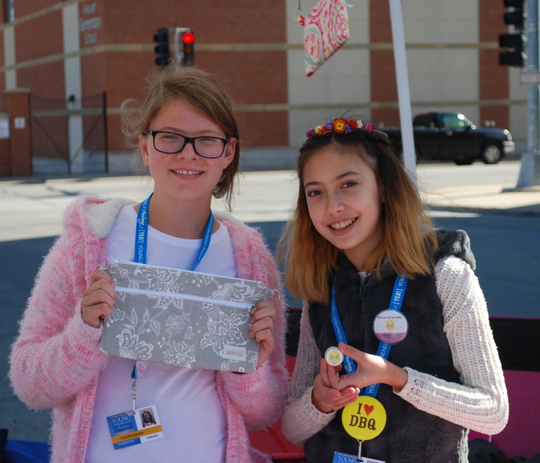 young girls showing off art work that they created