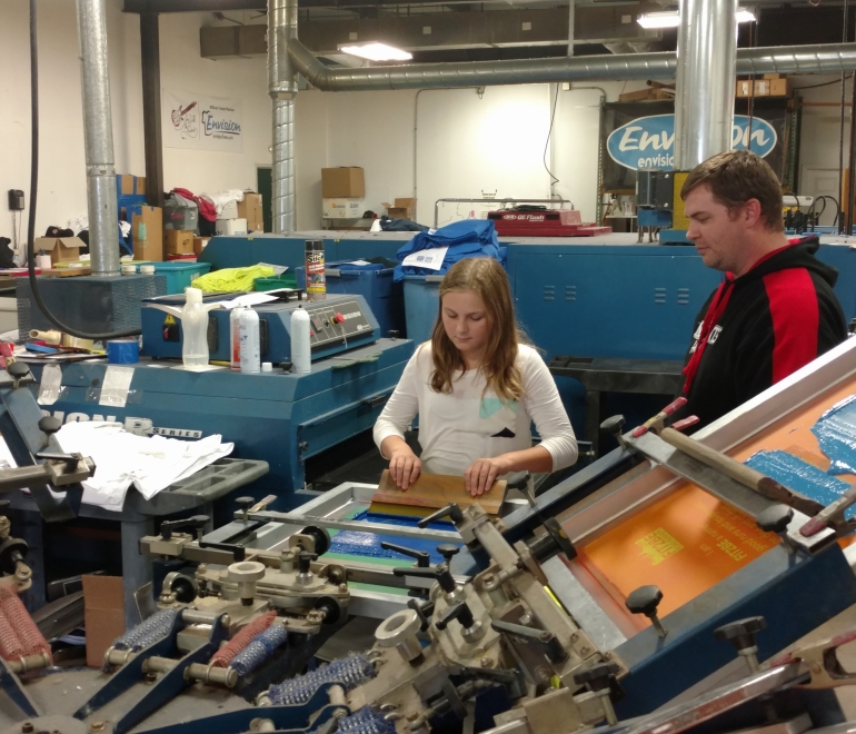 Young girl operating a screen press