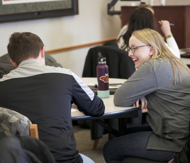 two people at a table talking