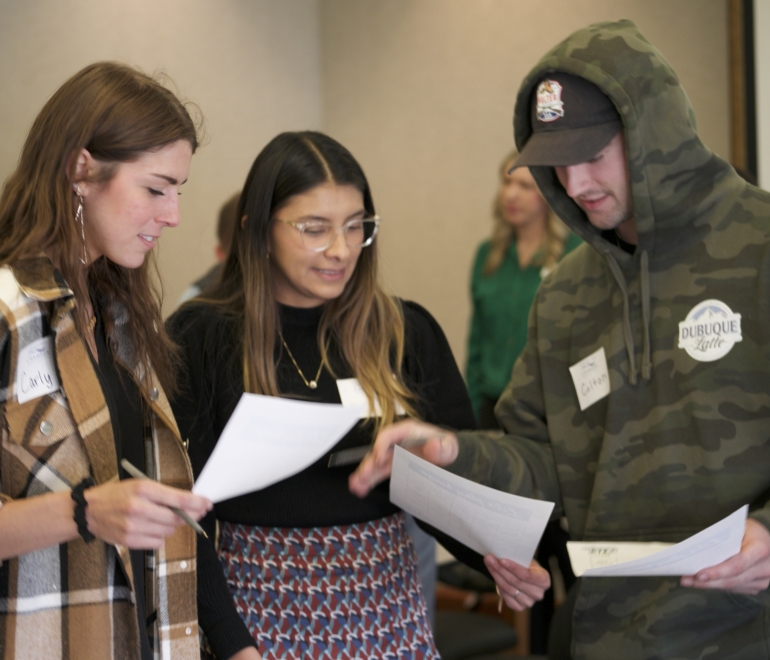 three people discussing a document