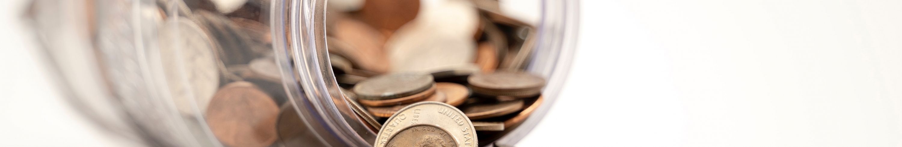 coins spilling out of a glass mason jar.